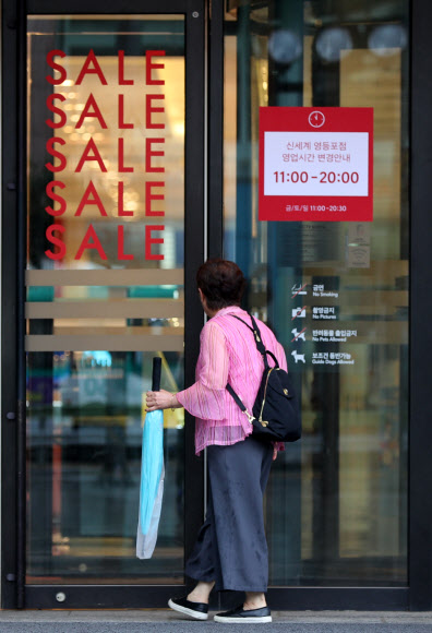 주 52시간 근무제 도입 후 첫 월요일인 2일 오전 서울 영등포구 신세계백화점 영등포점을 찾은 시민이 변경된 개점시간에 아직 문을 열지 않은 매장 내부를 들여다보고 있다. 신세계백화점은 면세점이 있는 본점과 강남점을 제외한 영등포점 등에서 개점시간을 10시 30분에서 11시로 변경한다.2018.7.2  연합뉴스