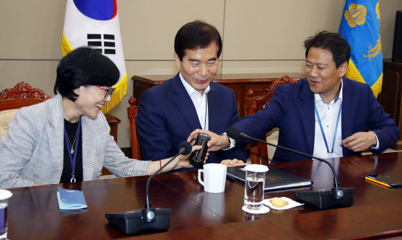 2일 오후 청와대 여민관에서 열린 수석ㆍ보좌관회의에서 참석한 임종석 비서실장(오른쪽)이 조현옥 인사수석이 가져 온 까만색 텀블러를 보여달라고 하고 있다. 청와대는 사무여건을 친환경적으로 개선하고 일회용품 줄이기에 앞장서기로 하며 사무실에서 일회용 플라스틱 소모품과 종이컵 사용을 자제하고 머그잔, 텀블러 등을 사용토록 권장하기로 했다. 2018.7.2  연합뉴스