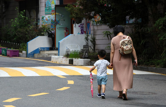 서울 서대문구 한 아파트 단지에서 우산을 든 아이가 엄마 손을 잡고 어린이집에 가고 있다. 연합뉴스