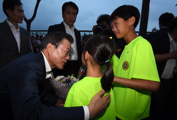 문재인 대통령이 5일 서울시 구로구 행복주택에서 신혼부부 및 청년 주거대책 발표 행사를 마친 후 아이들에게서 꽃다발을 받고 있다.  . 2018.07.05 도준석 기자 pado@seoul.co.kr