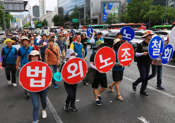‘법외노조 취소-노동3권 쟁취 전국교사결의대회’에 참가한 전국교직원노동조합(전교조) 조합원들이 6일 오후 서울 중구 서울파이낸스센터 앞에서 시위를하고 있다. 이날 참가자들은 법외노조 통보 취소, 해고자 복귀, 교사의 노동3권 보장, 성과급?교원평가 폐지를 촉구하며 연가투쟁을 벌였다. 2018.7.6이호정 기자hojeong@seoul.co.kr