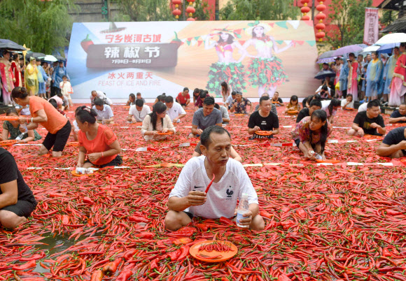 참가자가 8일(현지시간) 중국 후난성 중부의 닝샹(Ningxiang)에서 열린 ‘고추 먹기 대회’ 중 고추를 먹고 있다. 이 대회의 우승자는 1분 안에 50개의 고추를 먹었다. AFP 연합뉴스