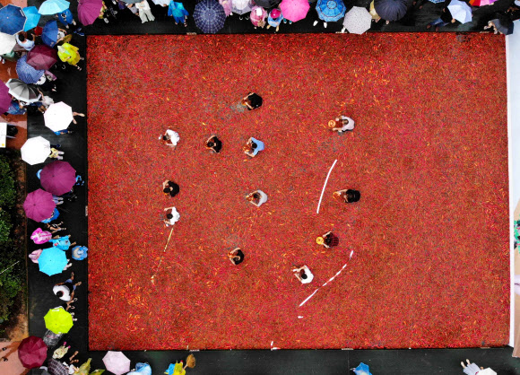 참가자가 8일(현지시간) 중국 후난성 중부의 닝샹(Ningxiang)에서 열린 ‘고추 먹기 대회’ 중 고추를 먹고 있다. 이 대회의 우승자는 1분 안에 50개의 고추를 먹었다. AFP 연합뉴스