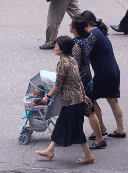 4일 오전 평양 고려호텔 맞은편 인도에 한 주민이 아이를 태운 유모차를 밀고 가고 있다.  사진공동취재단