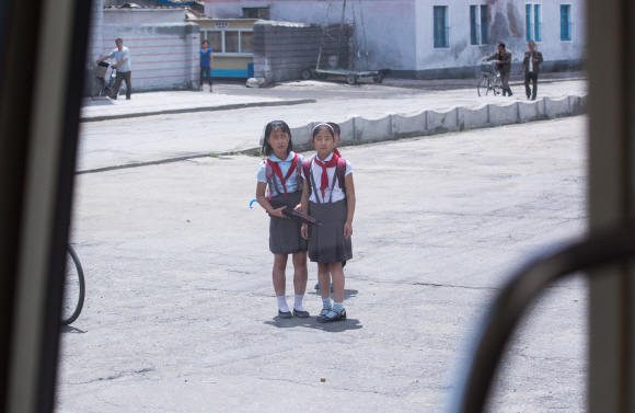 3일 오전 평양 순안공항에서 시내를 향하는 길에 어린이들이 지나가는 차량 행렬을 바라보고 있다.  사진공동취재단