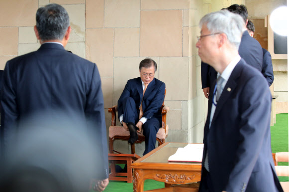 인도를 국빈방문 중인 문재인 대통령이 10일 오전(현지시간) 인도 뉴델리 간디 추모공원을 참배한 뒤 양말을 다시 신고 있다. 간디 추모공원은 맨발이나 슬리퍼를 신고서만 입장이 가능하다. 2018.7.10 연합뉴스