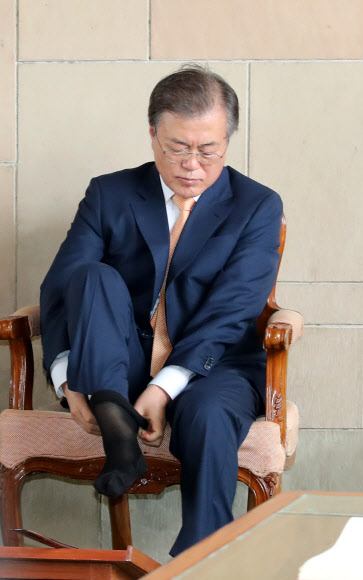 인도를 국빈방문 중인 문재인 대통령이 10일 오전 인도 뉴델리 간디 추모공원을 방문, 양말을 다시 신고 있다. 간디 추모공원은 맨발이나 슬리퍼를 신고 입장이 가능하다. 2018.7.10  연합뉴스