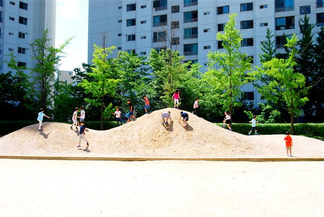 10일 서울 중랑구 신현초 안에 조성된 ‘꿈을 담은 놀이터’에서 학생들이 흙더미를 오르내리며 뛰어놀고 있다.  서울교육청 제공
