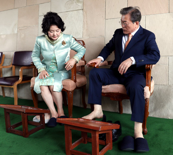 인도를 국빈방문 중인 문재인 대통령과 부인 김정숙 여사가 10일 오전 인도 뉴델리 간디 추모공원을 방문해 헌화를 마친 뒤 양말을 신고 있다. 간디 추모공원은 맨발이나 슬리퍼를 신고 입장이 가능하다. 2018.7.10  연합뉴스