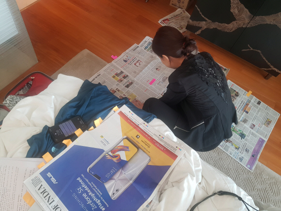 인도 조간신문을 모아 호텔방에 쭉 늘어놓고 꼼꼼하게 체크하는 해외언론비서관실 한송이 행정관.   청와대 제공