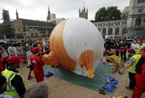도널드 트럼프 미국 대통령의 방문을 반대하는 시위대가 13일(현지시간) 영국 런던 의회 광장에서 기저귀를 찬 채 화내는 모습을 한 6ｍ 높이의 대형 ‘아기 트럼프’ 풍선을 띄웠다. AP 연합뉴스