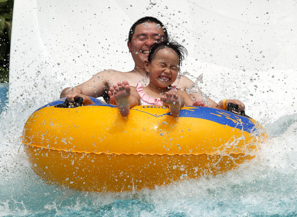 아빠와 딸이 14일(현지시간) 일본 도쿄의 워터파크에서 물놀이를 즐기고 있다. 도쿄의 일부 지역에서는 기온이 섭씨 36.5도에 달하며 연중 최고 기온은 평균 기온보다 7도 이상 높다. 기후현 타지미 (Tajimi)에서는 38.7 도로 평소보다 7.4도 높았다. EPA 연합뉴스