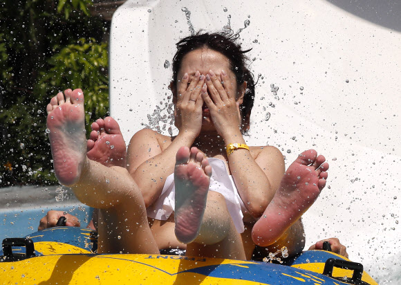 한 커플이 14일(현지시간) 일본 도쿄의 워터파크에서 물놀이를 즐기고 있다. 도쿄의 일부 지역에서는 기온이 섭씨 36.5도에 달하며 연중 최고 기온은 평균 기온보다 7도 이상 높다. 기후현 타지미 (Tajimi)에서는 38.7 도로 평소보다 7.4도 높았다. EPA 연합뉴스