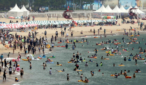 일요일이면서 폭염특보가 계속된 15일 부산 해운대해수욕장에서 피서객들이 물놀이를 하고 있다. 2018.7.15  연합뉴스