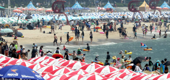 일요일이면서 폭염특보가 계속된 15일 부산 해운대해수욕장에서 피서객들이 물놀이를 하거나 바닷바람을 쐬며 더위를 식히고 있다. 2018.7.15  연합뉴스