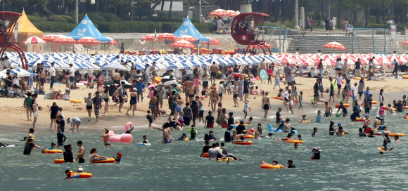 일요일이면서 폭염특보가 계속된 15일 부산 해운대해수욕장에서 피서객들이 물놀이를 하거나 바닷바람을 쐬며 더위를 식히고 있다. 2018.7.15  연합뉴스