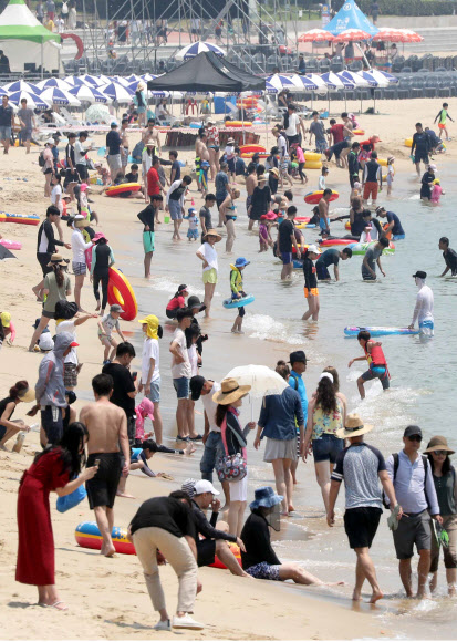 일요일이면서 폭염특보가 계속된 15일 부산 해운대해수욕장에서 피서객들이 물놀이를 하거나 바닷바람을 쐬며 더위를 식히고 있다. 2018.7.15  연합뉴스