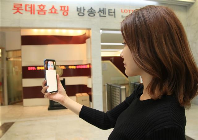 롯데홈쇼핑 방송센터에서 홍보 모델이 모바일 앱에 홍채 인증을 통한 로그인 시스템을 선보이고 있다. 롯데홈쇼핑 제공