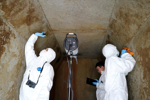 국립부여문화재연구소가 1917년 이후 한 세기 만에 다시 발굴한 익산 쌍릉 대왕릉에서 발견한 인골을 분석해 추정한 ‘60대 전후 남성 노인, 키 160∼170.1㎝, 사망 시점 620∼659년’이라는 결과를 18일 발표했다. 그러나 전주박물관이 2년 전 공개한 자료를 토대로 대왕릉에 매장된 인물은 남성이 아닌 여성일 가능성이 크고, 신라계 토기가 확인된다는 점에서 신라 진평왕 셋째 딸인 선화공주가 무덤 주인일 수도 있다는 의견이 조심스럽게 제시됐다. 사진은 익산 쌍릉 대왕릉 석실 벽면 조사 모습. 2018.7.18  국립부여문화재연구소 제공=연합뉴스