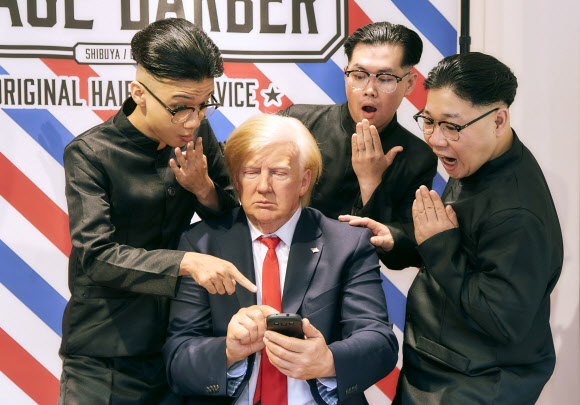 일본 도쿄 ‘마담 투소’ 밀랍인형 박물관에서 김정은 북한 국무위원장 헤어스타일을 한 모델들이 도널드 트럼프 미국 대통령 밀랍인형과 함께 촬영을 하고 있다. 지난 16일 박물관은 일일 ‘평화 이발소(Peace Barber)를 열고 김 위원장 헤어스타일을 재현한 커트 서비스를 제공했다. EPA 연합뉴스