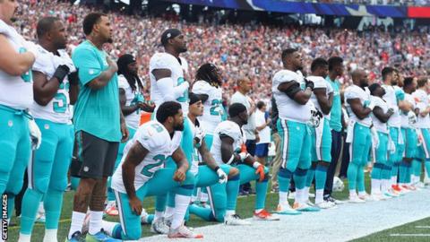 미국프로풋볼(NFL) 마이애미 돌핀스 구단 선수 일부가 국가가 연주되는 동안 무릎 꿇기 시위를 하고 있다. AFP 자료사진