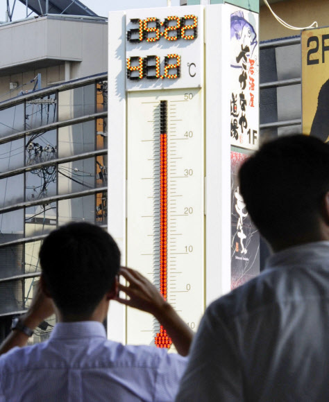 폭염에 지친 시민들이 40도 이상으로 치솟은 일본 중부 기후현 다지미시의 기차역 앞 대형 온도계 앞에서 발길을 멈춘 채 쳐다보고 있다. 도쿄도 오메시 40.8도, 사이타마현 구마가야 41.1도 등 유례없는 불볕더위가 일본 열도 각지를 달구면서 온열 질환으로 인한 희생자가 늘고 있다. 다지미 AP 연합뉴스
