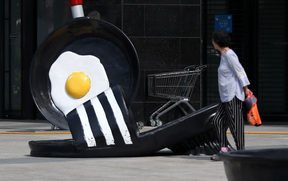 26일 오전 현대백화점 대구점 앞에 더위에 익은 달걀프라이와 녹아내린 슬리퍼 조형물이 시민들의 눈길을 사로잡고 있다. 이날 대구 중구청에 따르면 최근 보행을 방해하고 더위를 더욱 부채질하는 듯한 느낌이 들어 철거를 원한다는 내용의 민원이 들어와 관련 규정을 검토한 뒤 백화점 측에 철거를 요청했다. 2018.7.26  연합뉴스