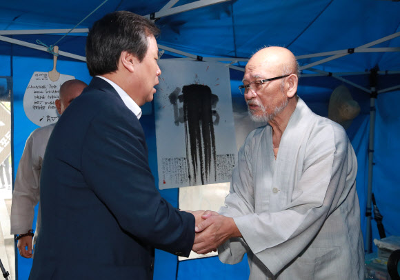 도종환 문화체육관광부 장관(왼쪽)이 27일 오전 서울 종로구 조계사 옆  단식 농성장에서 설조 스님과 인사를 나누고 있다. 세수 87세로 알려진 설조 스님은 지난달 20일 종단 적폐청산과 총무원장 설정 스님 퇴진 등을 요구하며 단식을 선언했다. 2018.7.27  연합뉴스