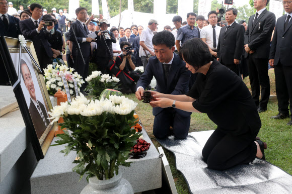 27일 오후 경기도 남양주시 모란공원에서 이정미 정의당 대표가 고(故) 노회찬 정의당 의원 묘소에 술잔을 올리고 있다. 2018.7.27  연합뉴스