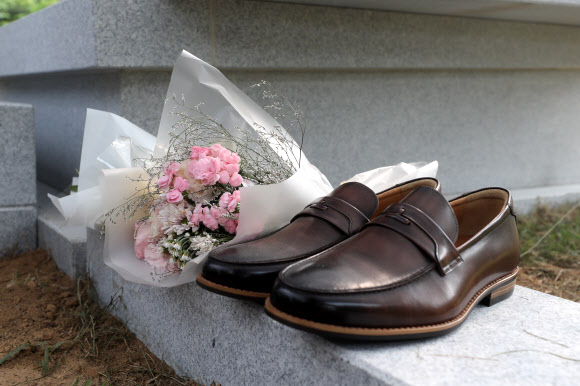 27일 오후 경기도 남양주시 모란공원에서 추모객들이 고(故) 노회찬 정의당 의원을 추모하며 새 구두를 묘소 앞에 올려 두었다. 2018.7.27  연합뉴스