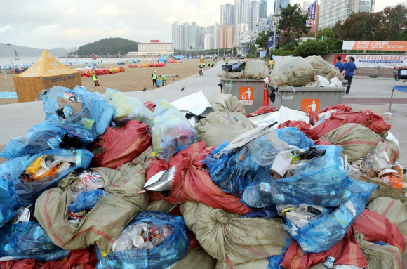 30일 부산 해운대해수욕장에서 수거한 각종 쓰레기가 쌓여 있다. 본격적인 휴가철을 맞아 일요일인 29일 해운대해수욕장에 50만명의 피서객이 찾았다. 피서객들이 백사장에 버리고 간 쓰레기를 30일 새벽 4시부터 환경미화원들이 수거해 재활용과 폐기용으로 분류한 것이다. 피서 성수기를 맞아 평소보다 2∼3배 많은 쓰레기가 발생하고 있다고 한다. 2018.7.30  연합뉴스