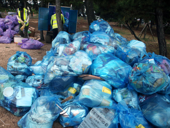 올여름 피서가 본격적으로 시작된 가운데 30일 새벽 강원 강릉시 경포 해수욕장에서 환경미화원이 수거해 온 쓰레기를 정리하고 있다. 2018.7.30  연합뉴스