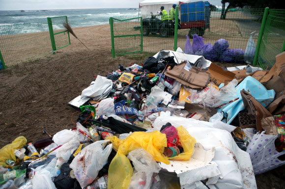 올여름 피서가 본격적으로 시작된 가운데 30일 새벽 강원 강릉시 경포 해수욕장 한쪽에 환경미화원이 수거해 온 쓰레기가 쌓여 있다. 2018.7.30  연합뉴스