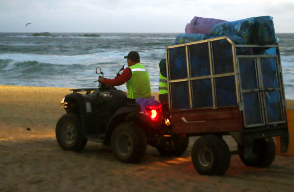 올여름 피서가 본격적으로 시작된 가운데 30일 새벽 환경미화원이 강원 강릉시 경포해수욕장에서 수거한 쓰레기를 옮기고 있다. 2018.7.30  연합뉴스