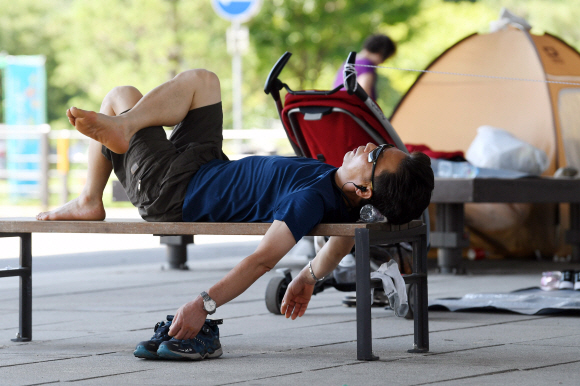 영등포구 여의도 한강공원을 찾은 한 시민이 마포대교 아래 그늘에 누워 휴식을 취하고 있다. 박윤슬 기자 seul@seoul.co.kr