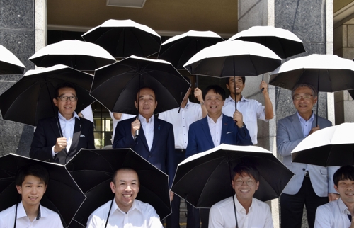 증정받은 양산을 써보는 우에다 기요시 사이타마현 지사(가운데). 교도 연합뉴스