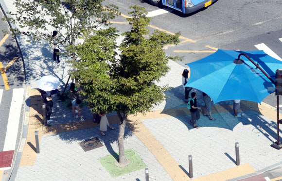 강한 햇살 피해 그늘로 들어간 시민들