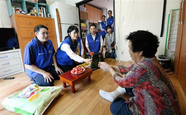 조현준(왼쪽 첫 번째) 효성 회장이 지난 1일 서울 마포구 성산동 취약 계층 가구를 방문해 수박과 쌀을 전달한 뒤 담소를 나누고 있다. 효성 제공