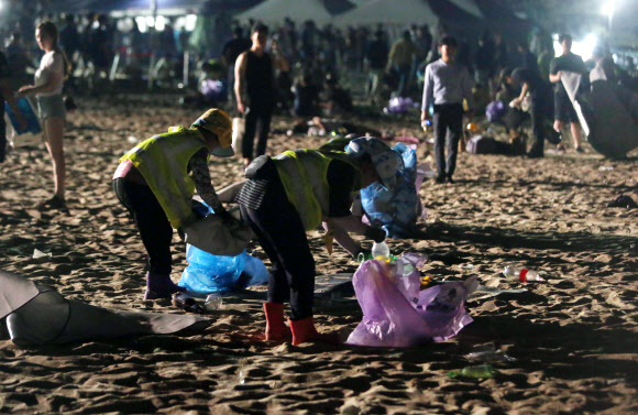 올여름 피서가 절정에 달한 4일 새벽 강원 강릉시 경포해수욕장에서 환경미화원이 피서객들이 밤사이 백사장에 버리고 간 쓰레기를 줍고 있다. 환경미화원들의 고된 쓰레기 수거작업은 새벽 4시부터 시작된다. 2018.8.4  연합뉴스