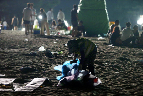 올여름 피서가 절정에 달한 4일 새벽 강원 강릉시 경포해수욕장에서 환경미화원이 피서객들이 밤사이 백사장에 버리고 간 쓰레기를 줍고 있다. 환경미화원들의 고된 쓰레기 수거작업은 새벽 4시부터 시작된다. 2018.8.4  연합뉴스