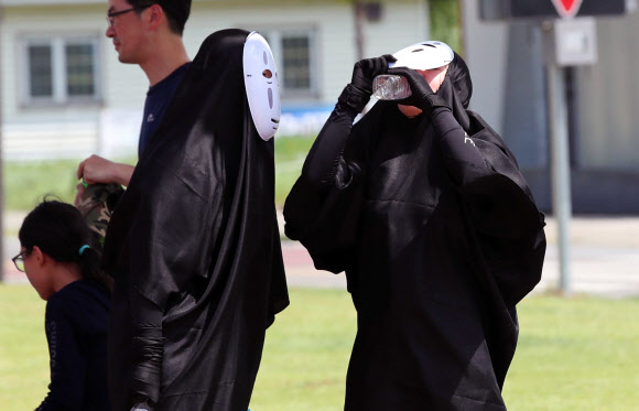 주말에도 푹푹 찌는 무더위가 계속되고 있는 4일 오후 서울 마포구 난지한강공원에서 한강 물싸움 축제 참가자들이 일본 애니메이션 캐릭터 가오나시 분장을 하고 물을 마시고 있다. 2018.8.4  연합뉴스