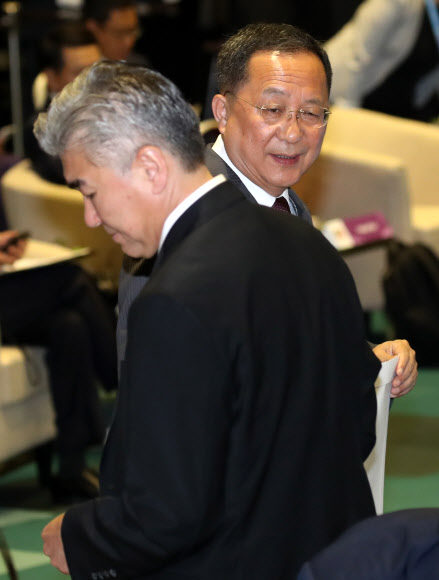 성 김 필리핀주재 미국대사가 4일 싱가포르 엑스포 컨벤션센터에서 열린 아세안지역안보포럼(ARF) 포토세션이 끝난 뒤 리용호 북한 외무상에게 다가가 서류봉투를 전달한 뒤 이야기를 나누고 자리로 향하고 있다. 2018.8.4  연합뉴스