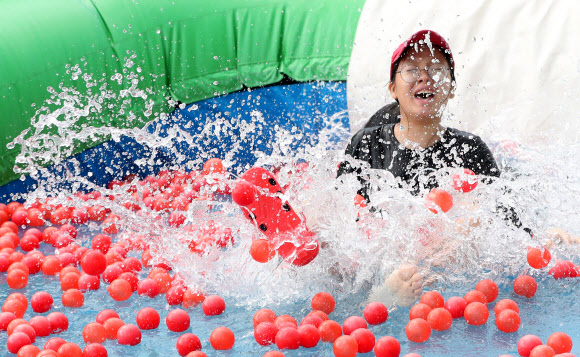 4일 오후 강원 화천군 사내면 문화마을에서 열린 ‘2018 화천토마토축제’를 찾은 어린이가 워터 슬라이드를 타며 무더위를 쫓고 있다. 2018.8.4  연합뉴스
