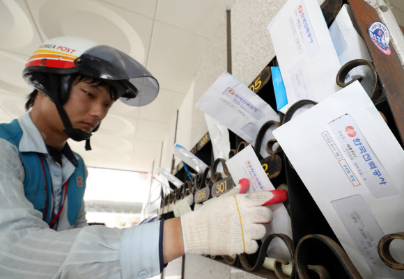 7일 우체국 직원이 세종시 조치원읍 한 다세대주택 우편함에 한국전력공사가 발송한 7월분 전기요금 청구서를 넣고 있다. 이날 백운규 산업자원부 장관은 “전기요금 누진제를 7월과 8월 두 달간 한시적으로 완화하겠다”고 밝혔다. 2018.8.7  연합뉴스