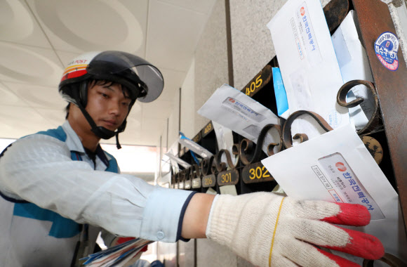 7일 우체국 직원이 세종시 조치원읍 한 다세대주택 우편함에 한국전력공사가 발송한 7월분 전기요금 청구서를 넣고 있다. 이날 백운규 산업자원부 장관은 “전기요금 누진제를 7월과 8월 두 달간 한시적으로 완화하겠다”고 밝혔다. 2018.8.7  연합뉴스