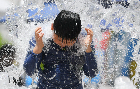지난달 31일 서울광장 앞 분수에서 한 어린이가 물놀이를 하며 더위를 식히고 있다. 박윤슬 기자 seul@seoul.co.kr