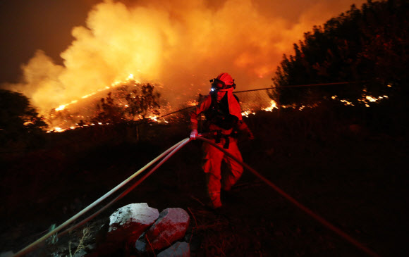 9일(현지시간) 미국 캘리포니아주 오렌지카운티와 리버사이드카운티 경계지점인 클리블랜드 국유림에서 발화한 ‘홀리 파이어’로 주에 위치한 산 곳곳이 불타고 있다. 캘리포니아 소방국은 현재 주내에 발화한 15개 산불을 진화하기 위해 1만 4000여 명의 소방대원이 투입돼 있다고 밝혔다. AFP 연합뉴스