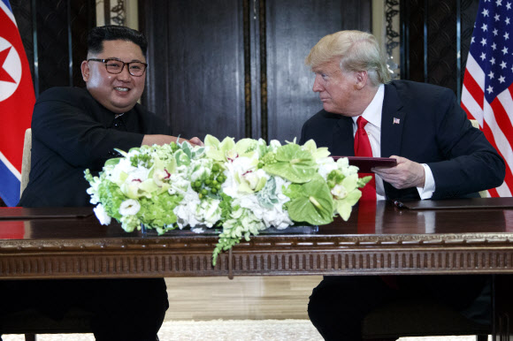 김정은(왼쪽) 북한 국무위원장과 도널드 트럼프(오른쪽) 미국 대통령이 지난 6월 12일 싱가포르 센토사섬 카펠라 호텔에서 열린 북·미 정상회담에서 공동 성명에 서명한 뒤 악수를 나누고 있다. 싱가포르 AP 연합뉴스 