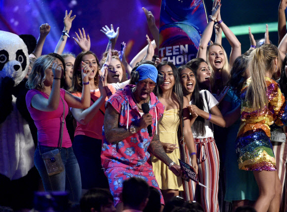 영화배우 닉 캐논(가운데)이 12일(현지시간) 미국 캘리포니아주 잉글우드에서 미국 방송사 폭스 주관으로 열린 ‘2018 틴 초이스 어워즈(Teen Choice Awards)’에서 ‘초이스 팬덤(Choice Fandom)’ 부문 수상자로 방탄소년단의 팬클럽 ‘아미’를 소개하고 있다.<br>AP 연합뉴스