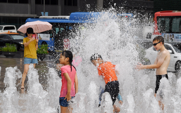 갑작스런 소나기가 내린 8월 9일 오후 비는 아랑곳하지 않는 어린이들이 서울광장 분수에서 물놀이를 즐기고 있다. 2018.8.9 도준석 기자 pado@seoul.co.kr